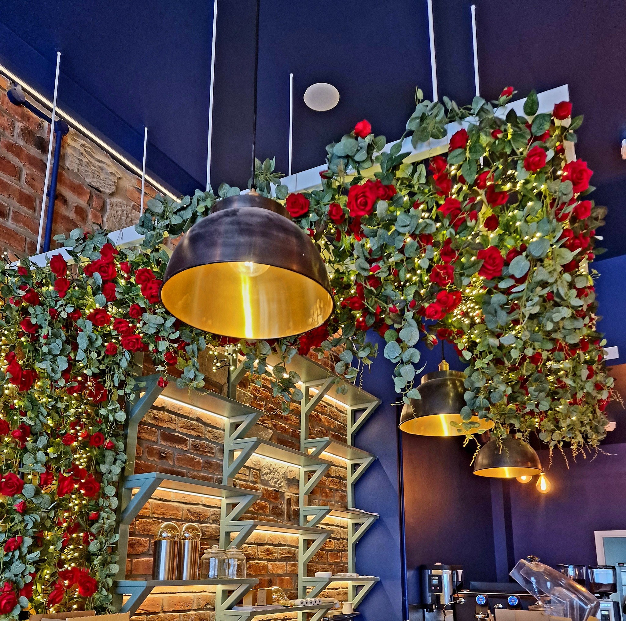 Inside Cafe Amara looking up at gold pendant lights and red floral decorations